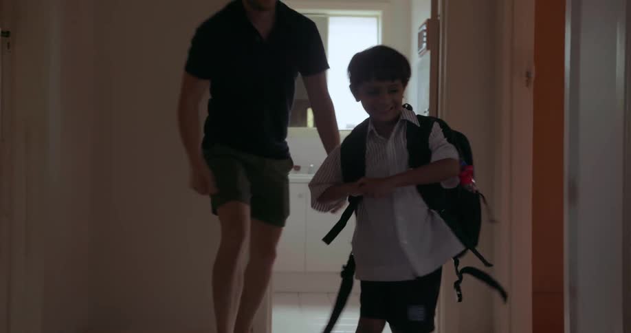 A father helps his son get ready for school