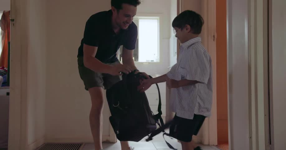 A father helps his son get ready for school