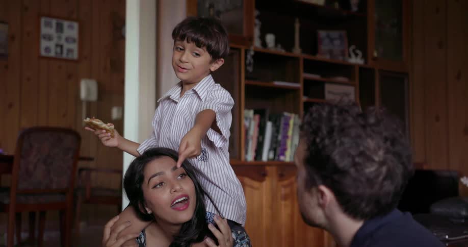 A mother, father and child play together on the floor