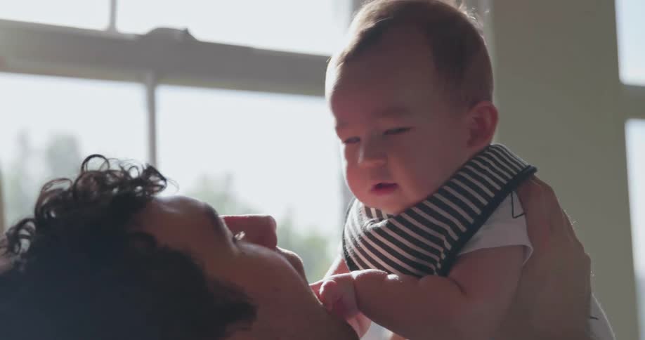A man holds a baby above his head