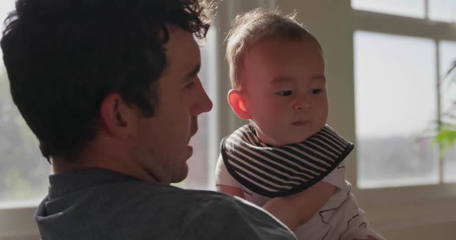 A man is rubbing the head of a baby
