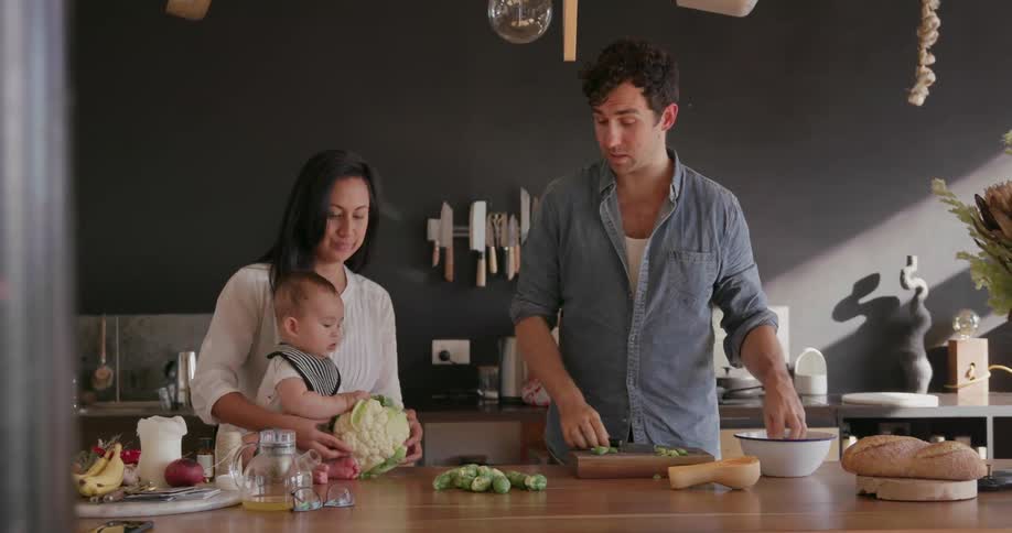A couple and their baby cook at home