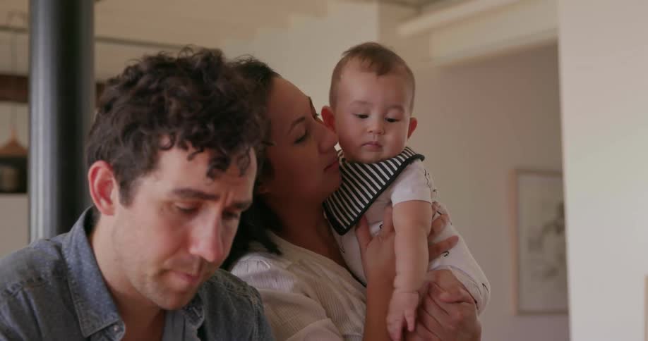 Man woman and baby stand in a house