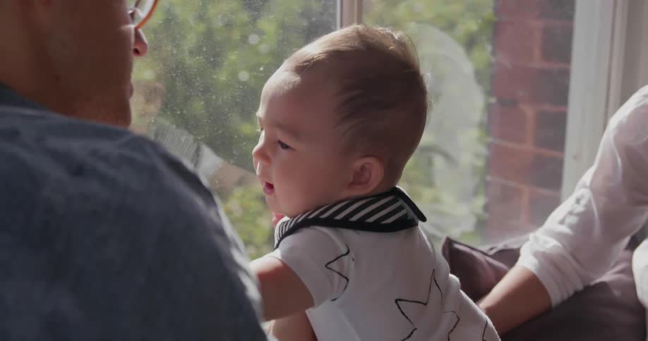 Parents and a baby look out of the window