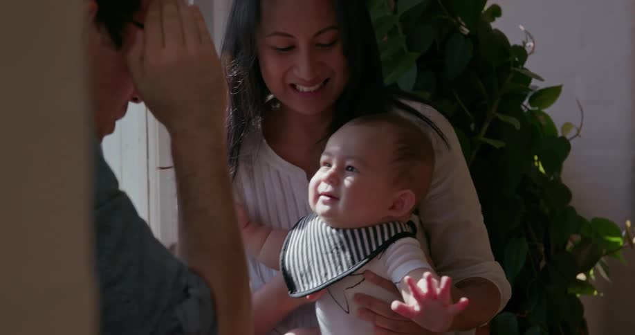 A man and woman play a game with their baby