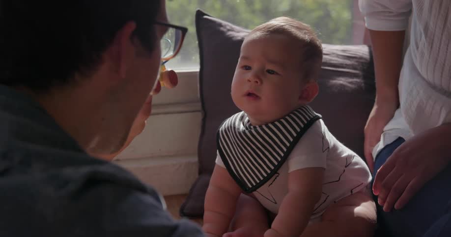 A man shows a baby a small toy