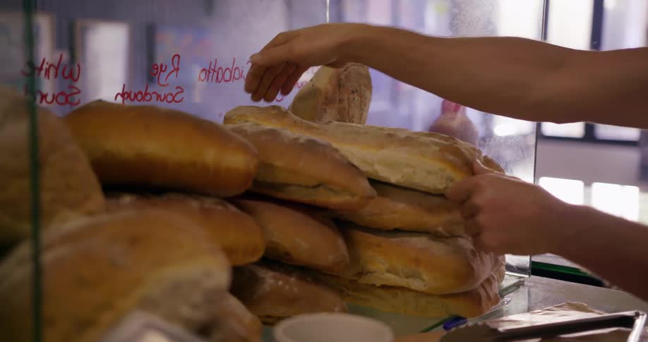 Person puts bread on a pile of bread
