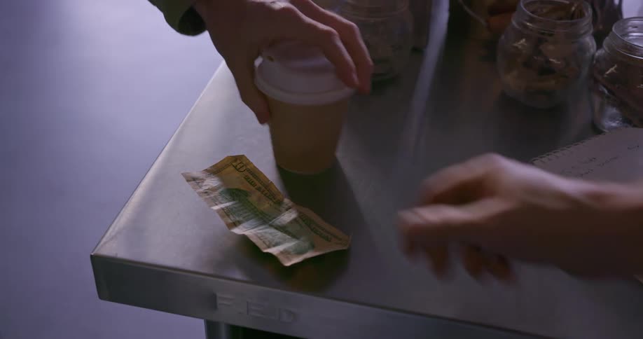 A person pays for a cup of coffee