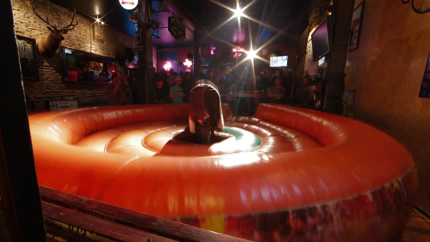 Time lapse of people riding a mechanical bull