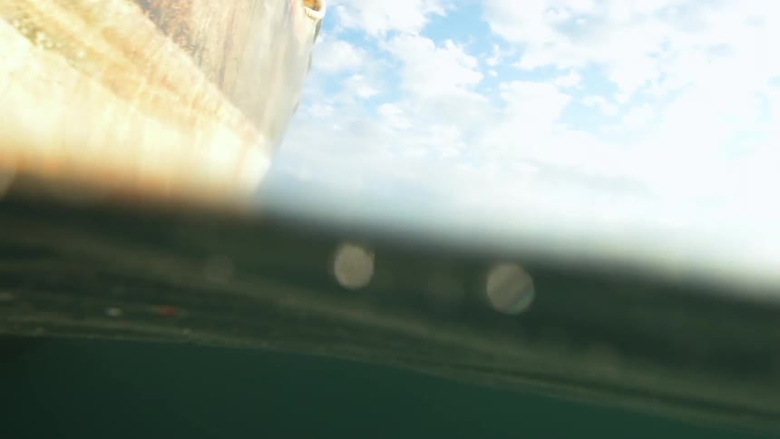 View of a ship hull at water level on a cloudy day