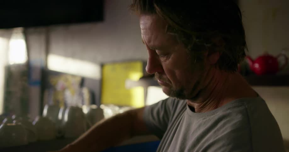 A man cleans metal containers with steaming water