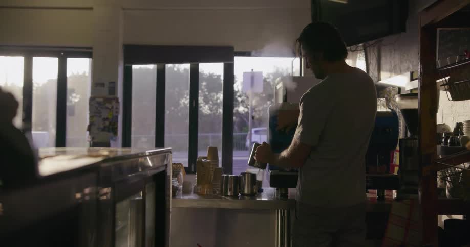 A man in a cafe makes coffee