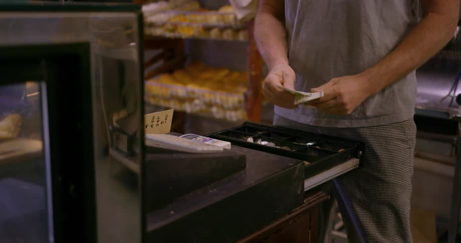 Man puts money in a cash register