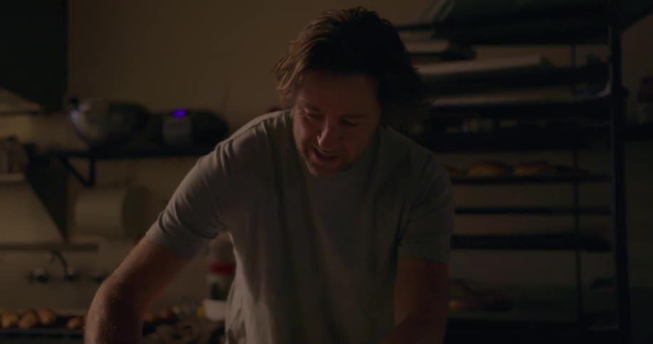 A man is working with dough in a kitchen