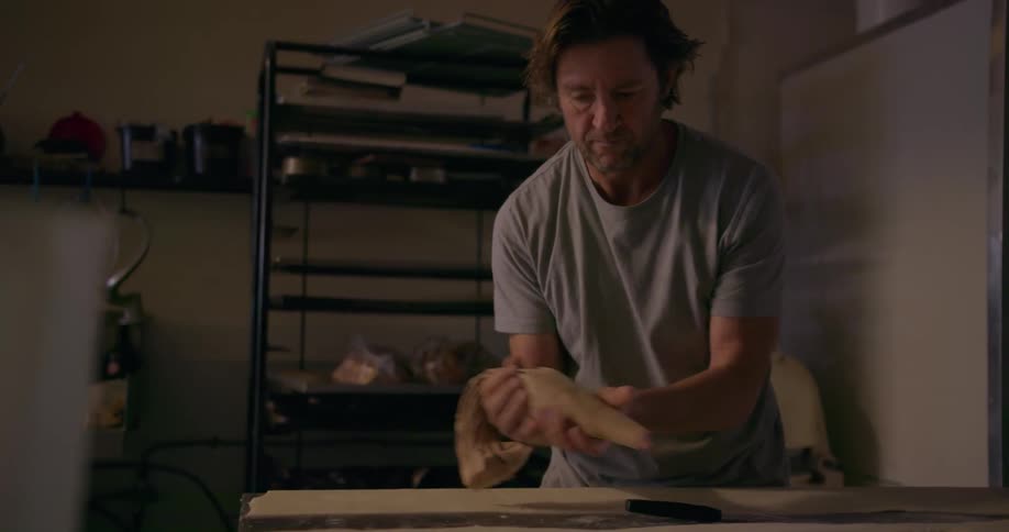A man cuts the dough in a kitchen