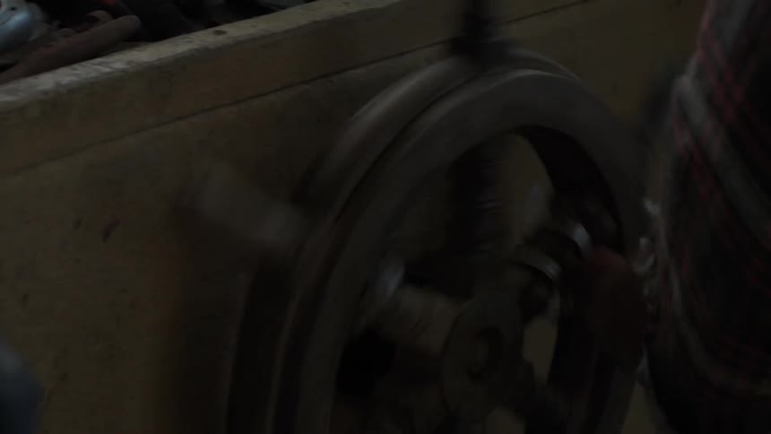 A hand rotates the helm of a boat