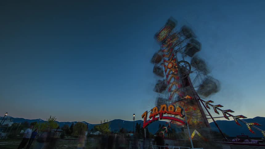 Time lapse of a carnival with people and rides moving rapidly