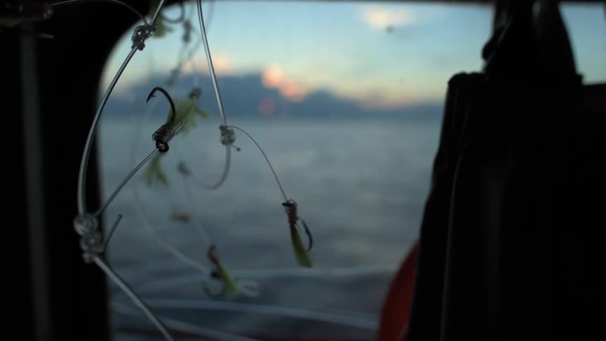 Fishing hooks dangle from a boat ceiling