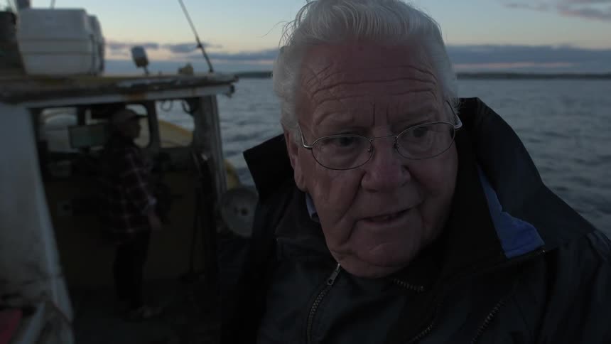 A man is on his boat at sunset