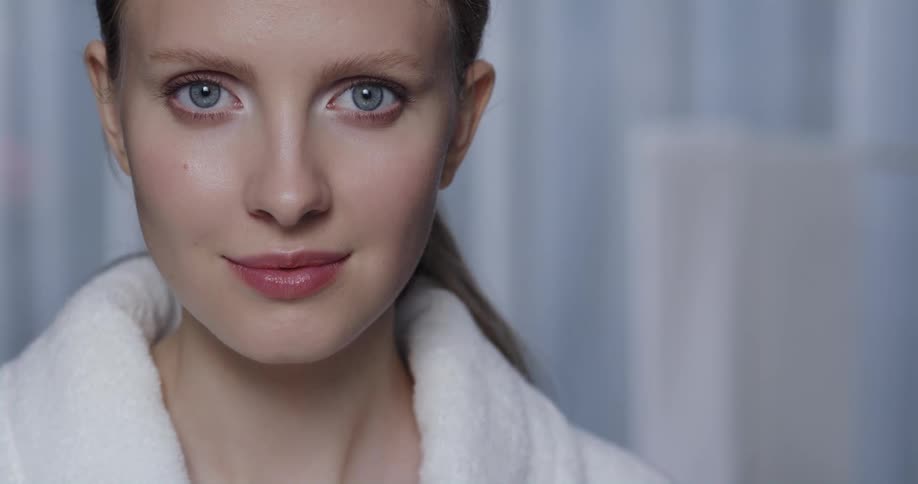 A woman turns her head to stare into the camera for a moment before grinning