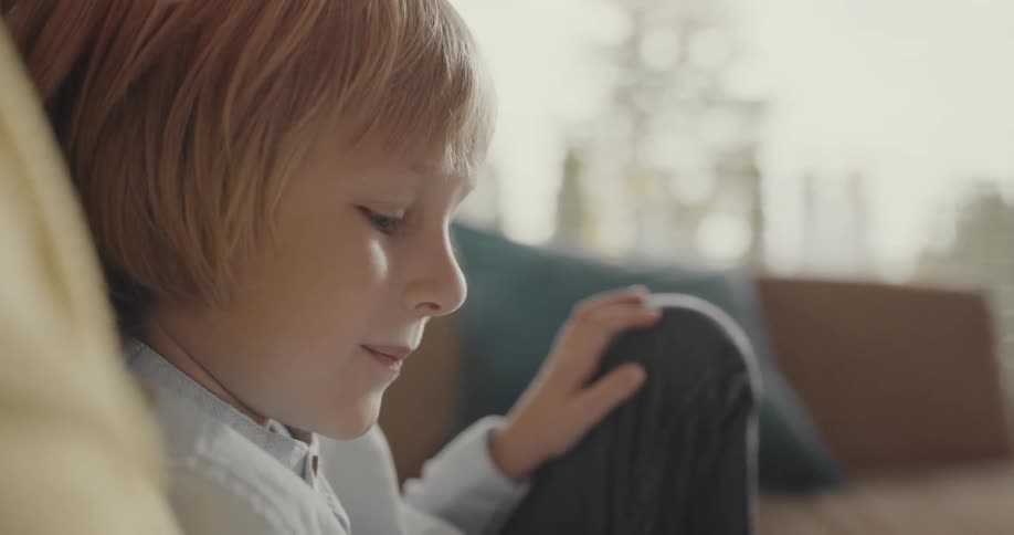 A child reads a book with an adult