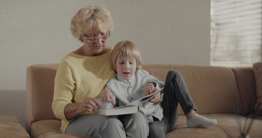 A grandson and grandma reading a book together