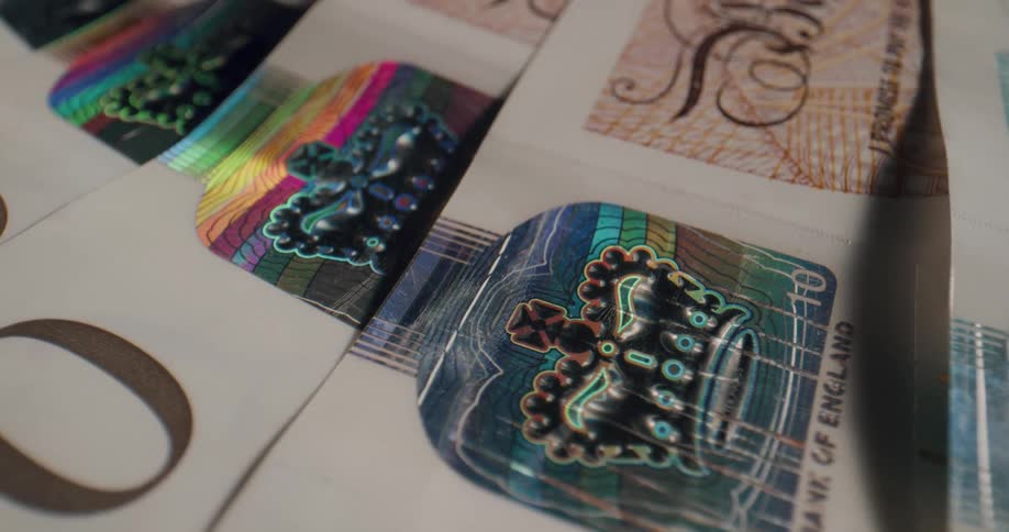 Ornate crown graphic and calligraphy decorate several english paper currency notes