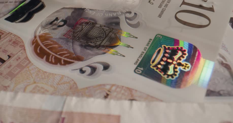 A variety of british banknotes lying atop a flat surface
