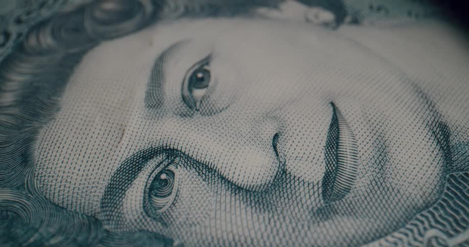 Close up of the face of the queen of england on a bank note