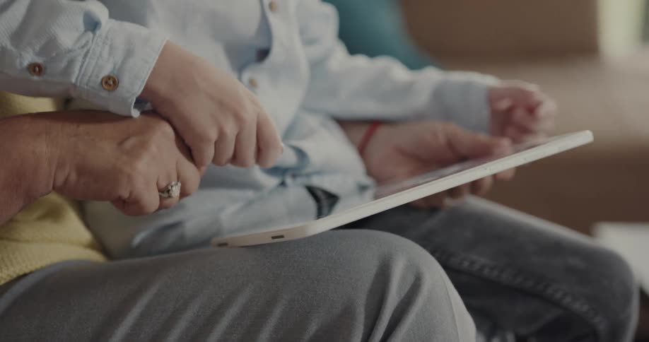 Grandmother and grandson playing a videogame on a tablet together