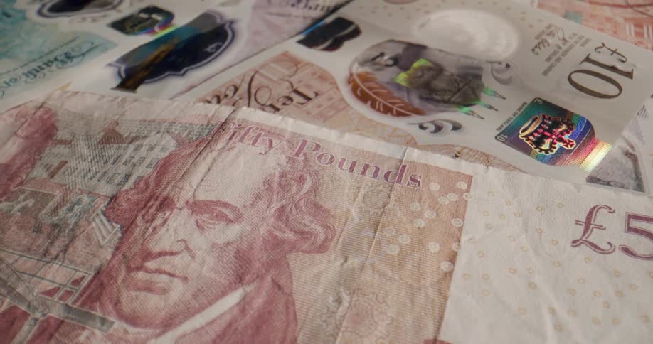 A pile of british banknotes lying on a surface