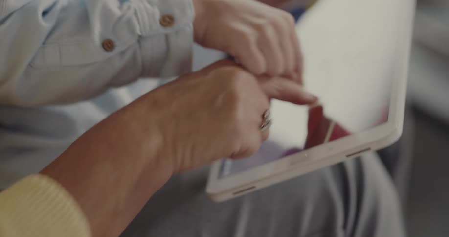 Grandmother and grandson playing a videogame on a tablet together