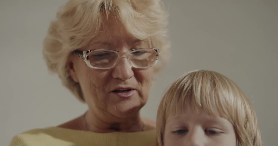 Grandmother sits closely to grandchild while she reads a book