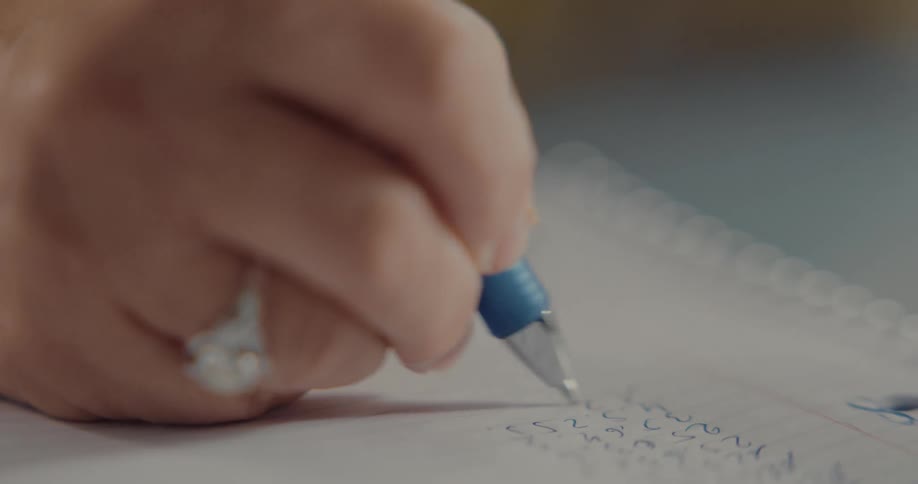 A woman is writing down numbers on a piece of paper