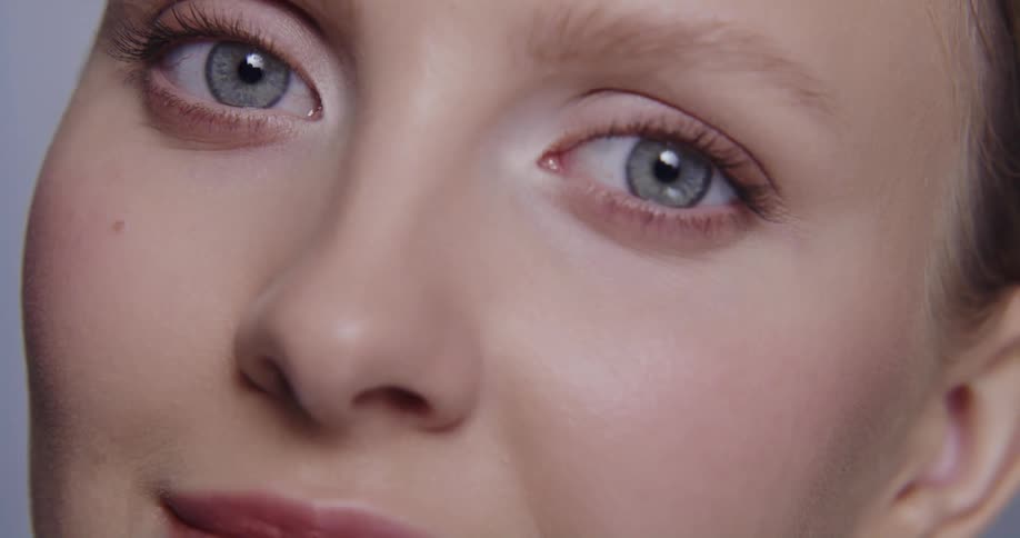 Closeup view of a womans face wearing makeup is displayed