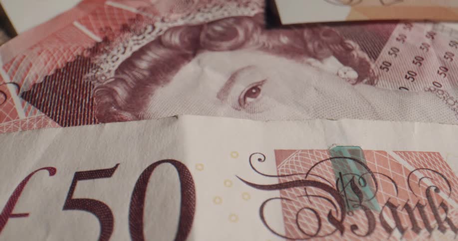 A messy pile of british banknotes