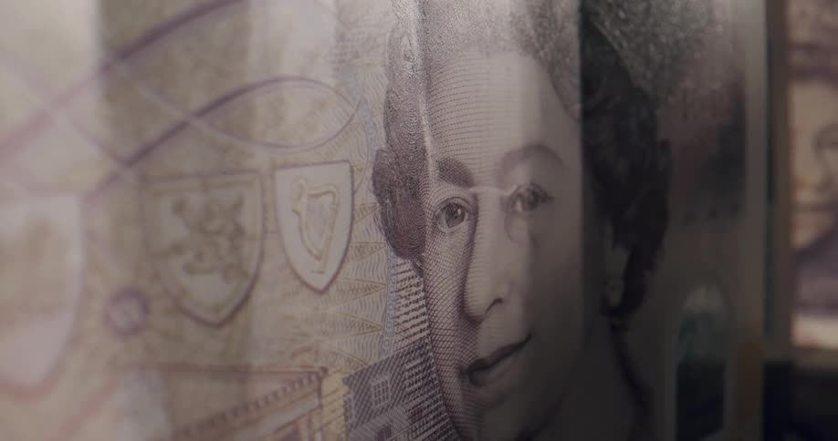 Close up of the face of the queen of england on a bank note