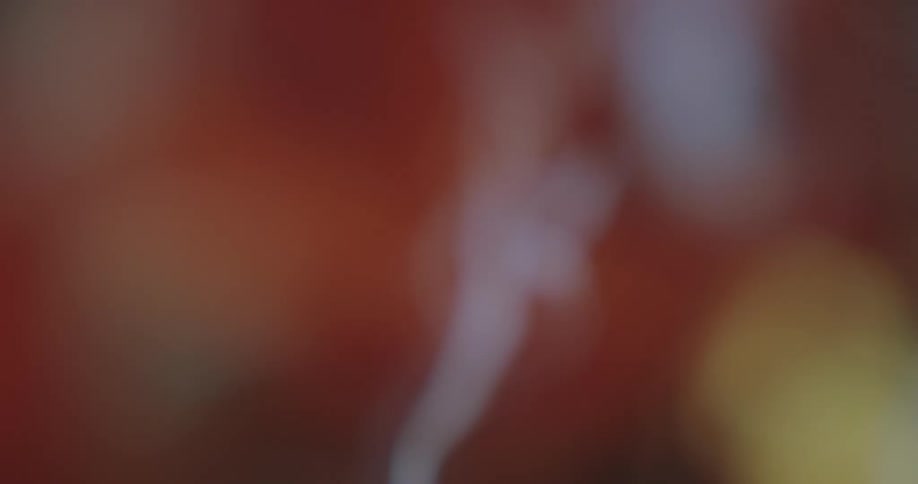 White smoke rising against a blurred orange background