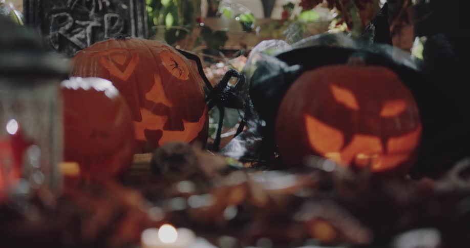 A halloween display of jack olanterns and candles is on a table
