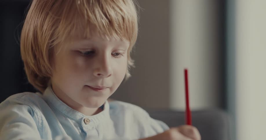 A young boy and another person are using color pencils and drawing