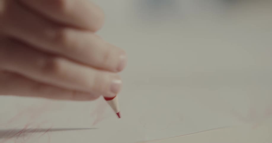 A person is drawing with a colored pencil