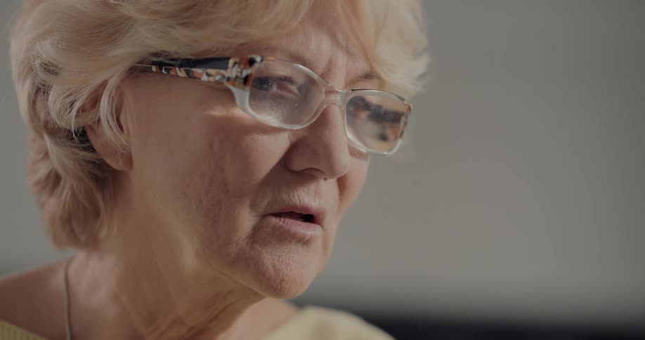 A woman puts on her reading glasses