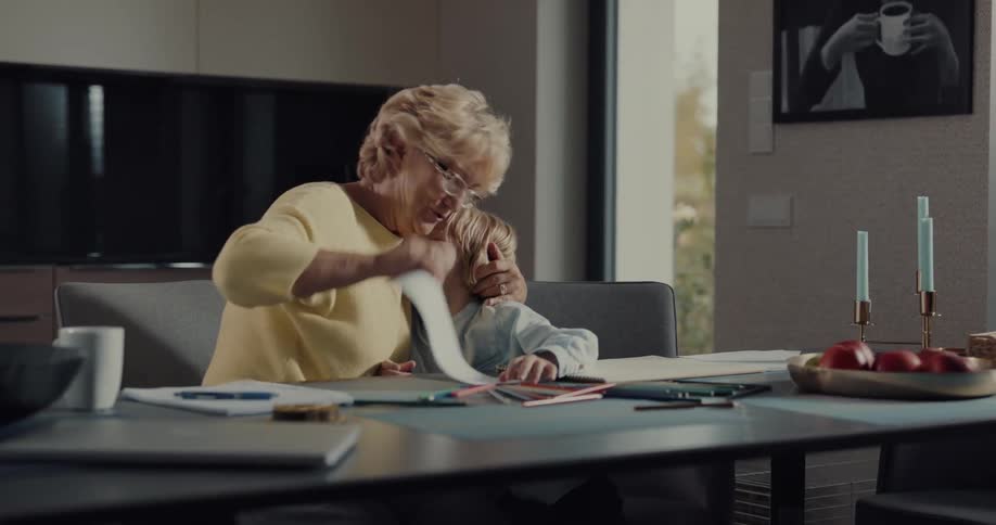 A grandmother kisses and hugs her grandson