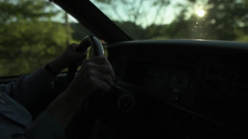 Close up on hands of man driving truck