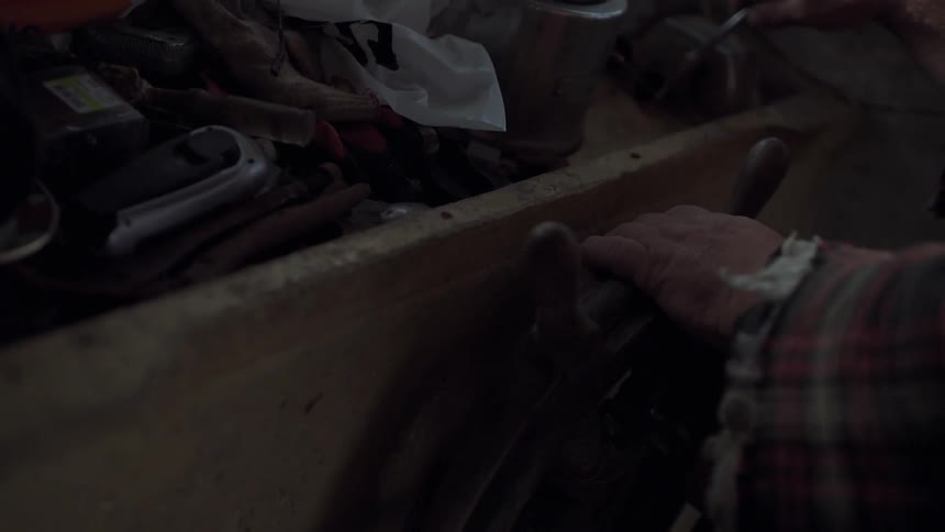 A man is turning a wooden wheel