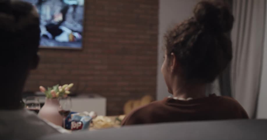 Two people are watching some television