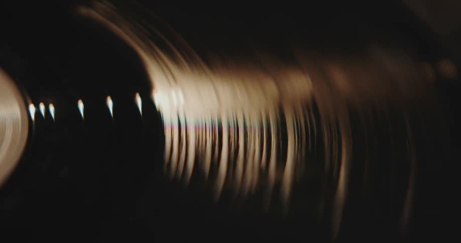Light shines on an a vinyl record spinning on an old turntable