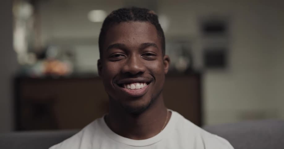 A teenage boy looks up and smiles for a portrait