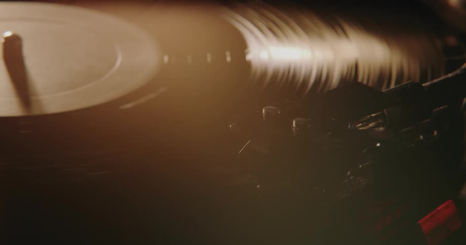 Light shines on an a vinyl record spinning on an old turntable