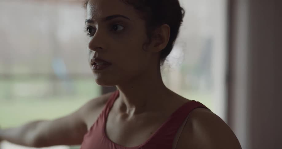 Young woman holds yoga poss in the living room at home